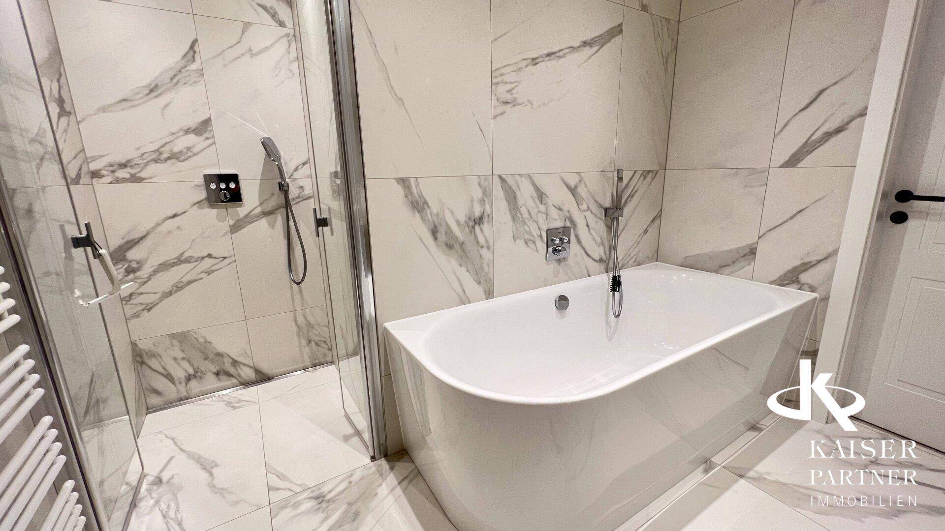 Elegantes Badezimmer mit Badewanne, begehbarer Dusche und hochwertigen Marmorfliesen.
