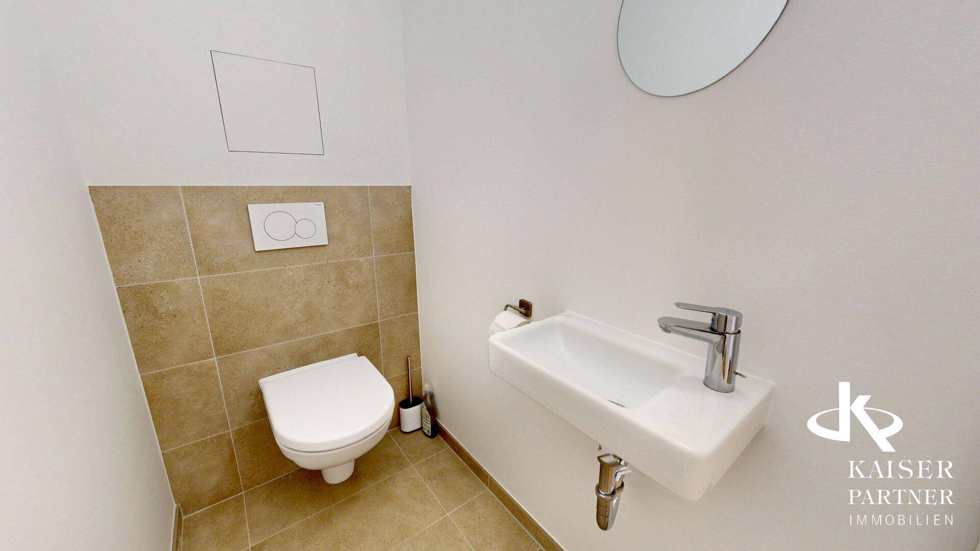 Kleines Gäste-WC mit Wand-WC und modernem Waschbecken, funktional und platzsparend.