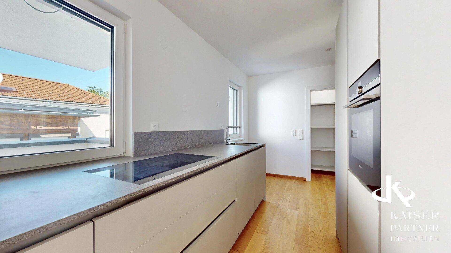 Helle Küche mit Induktionskochfeld, Spüle und Blick nach draußen, ideal für kulinarische Aktivitäten.