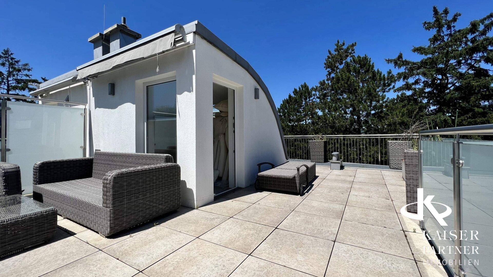 Moderne Dachterrasse mit bequemen Outdoor-Möbeln und weitem Blick in die grüne Umgebung.
