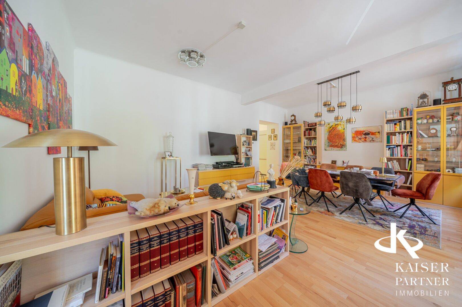 Heller Wohn-Essbereich mit Holzboden, Bücherregalen und modernem Essbereich.