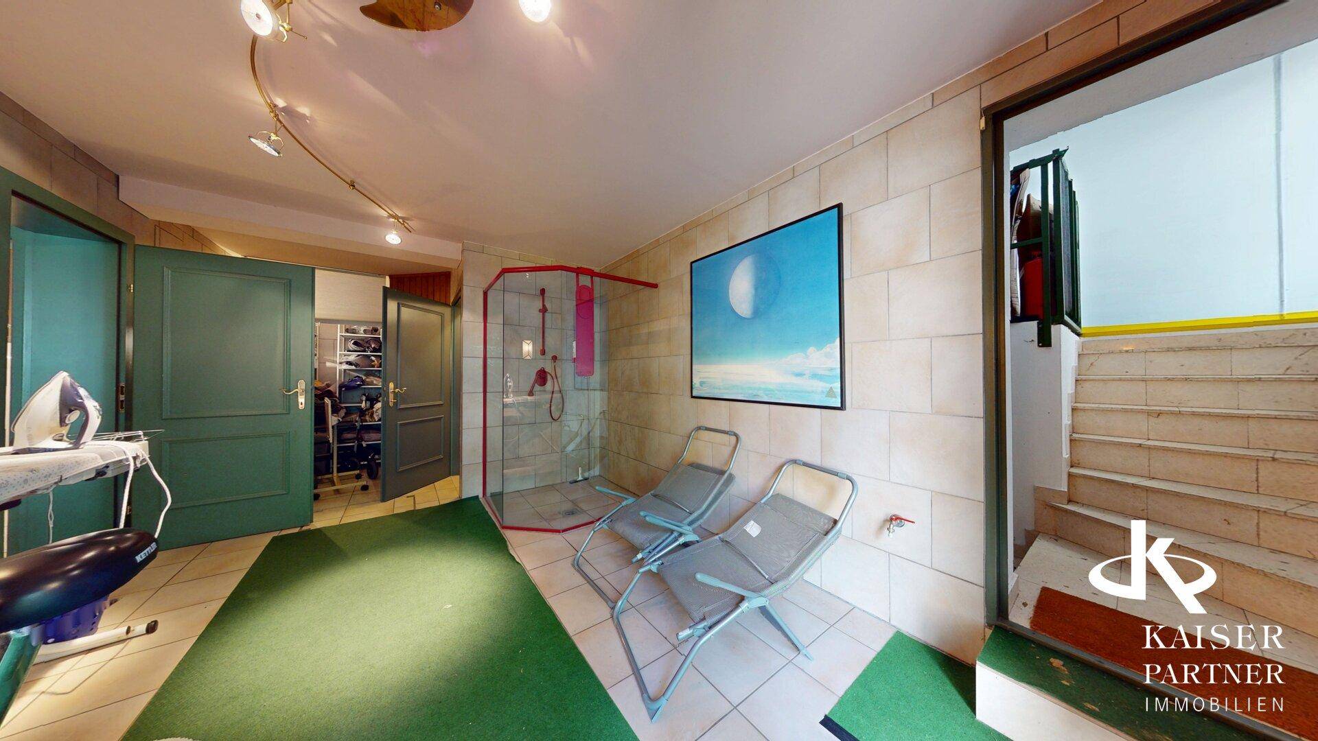 Heller Wellnessbereich mit Dusche, Liegestühlen und Zugang zu einer Treppe.