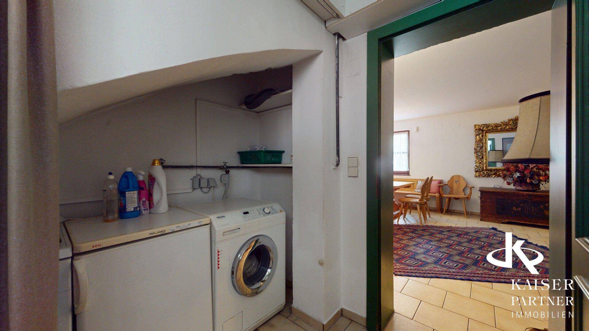 Funktionale Waschküche mit Waschmaschine und Trockner, angrenzend an den Essbereich.
