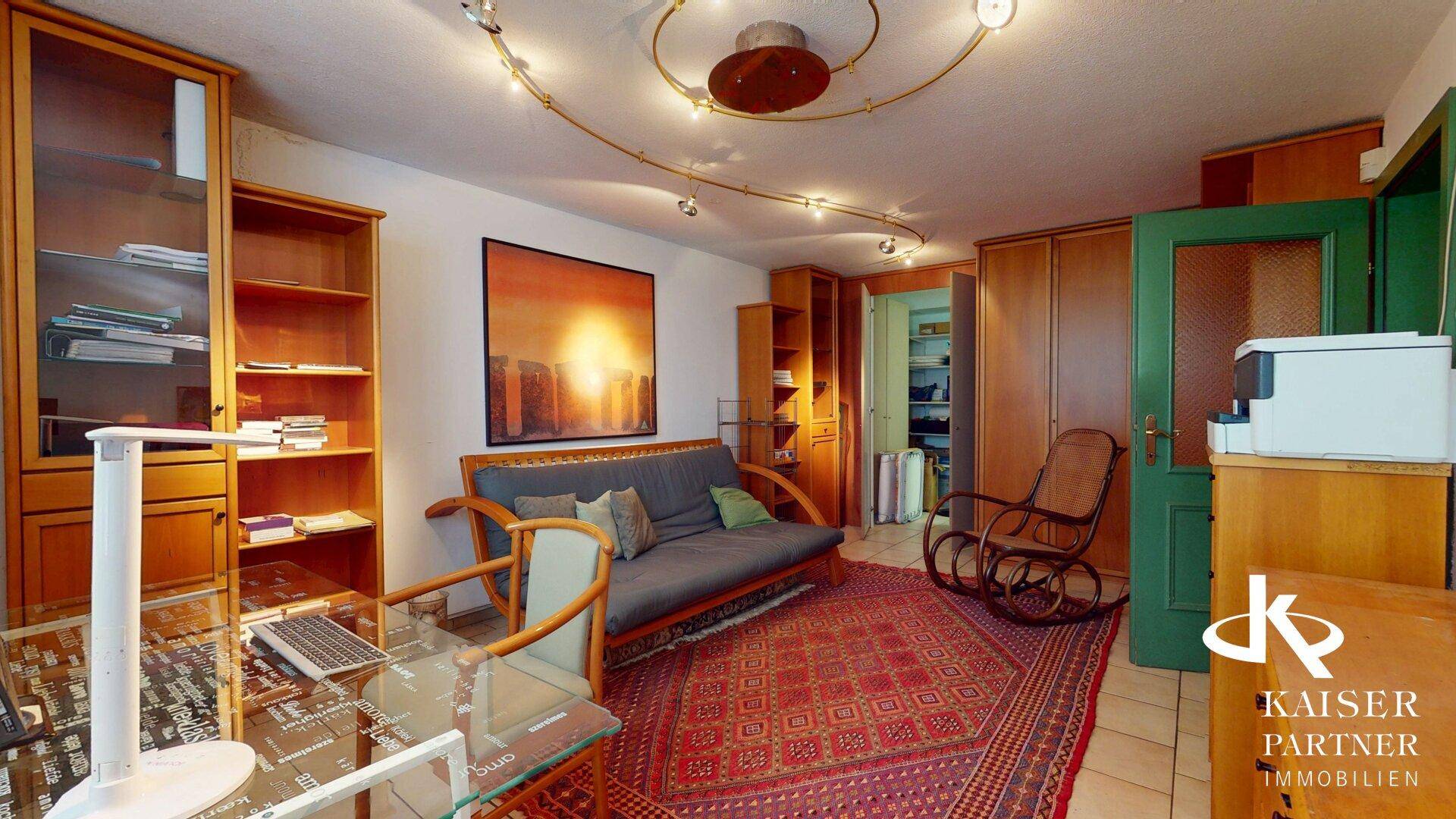 Arbeitszimmer mit Holzmöbeln, Sofa und Teppichboden.