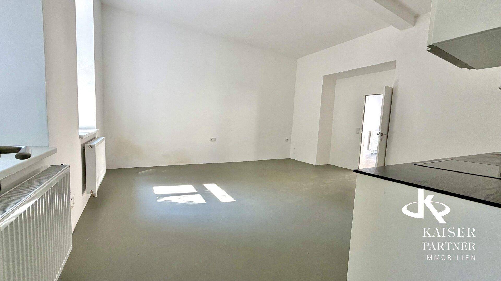 Heller, leerer Raum mit weiß gestrichenen Wänden und großem Fenster, ideal für Wohn- oder Bürozwecke.
