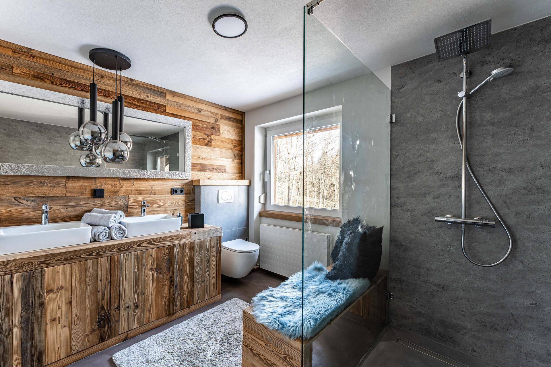 Luxuriöses Badezimmer mit Doppelwaschbecken, begehbarer Dusche und Holzelementen.