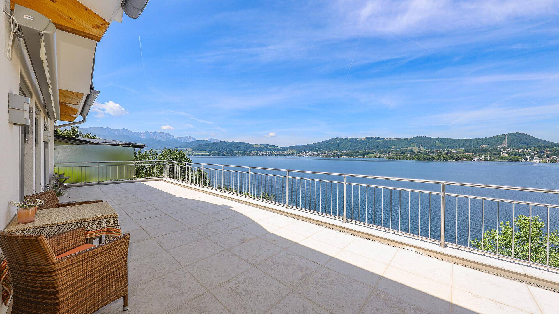 Geräumige Terrasse mit Sitzgelegenheiten und einem weiten Blick über den See und die umliegende Landschaft.