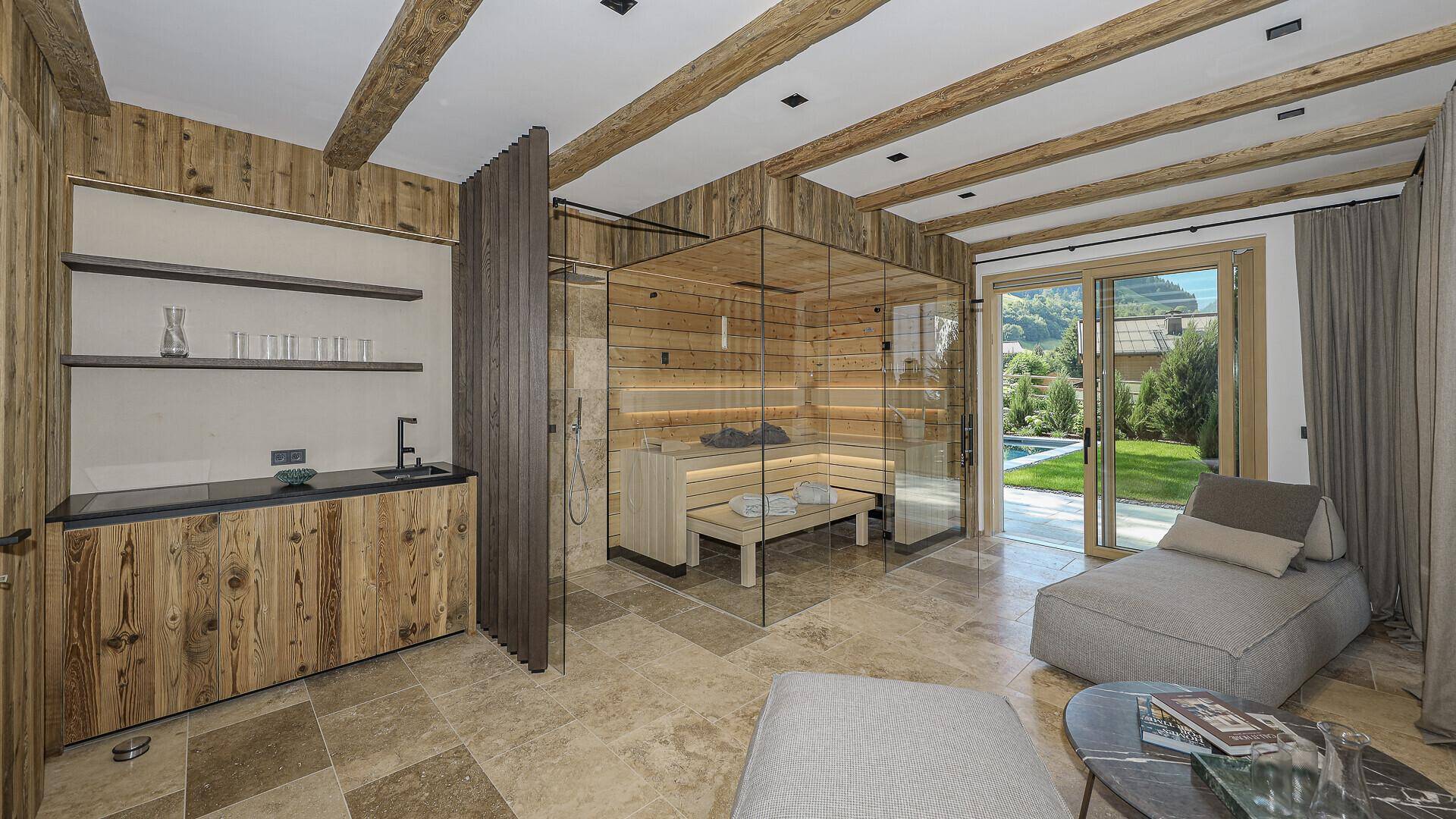 Exklusiver Wellnessbereich mit Sauna, Dusche und Liegeflächen, mit Zugang zum Garten und Pool.