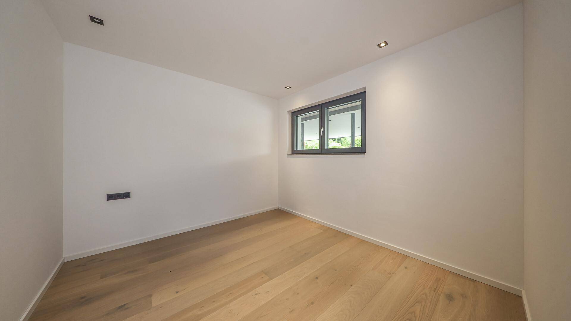 Helles Zimmer mit Holzboden und Fenster, ideal als Schlaf- oder Arbeitszimmer.