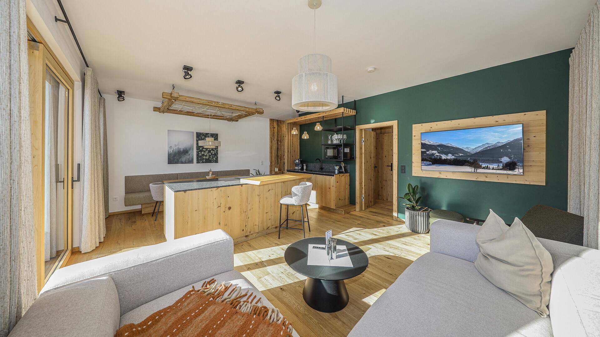 Offener Wohnbereich mit integrierter Küche, Essbereich und gemütlichem Sofa in modernem Design.