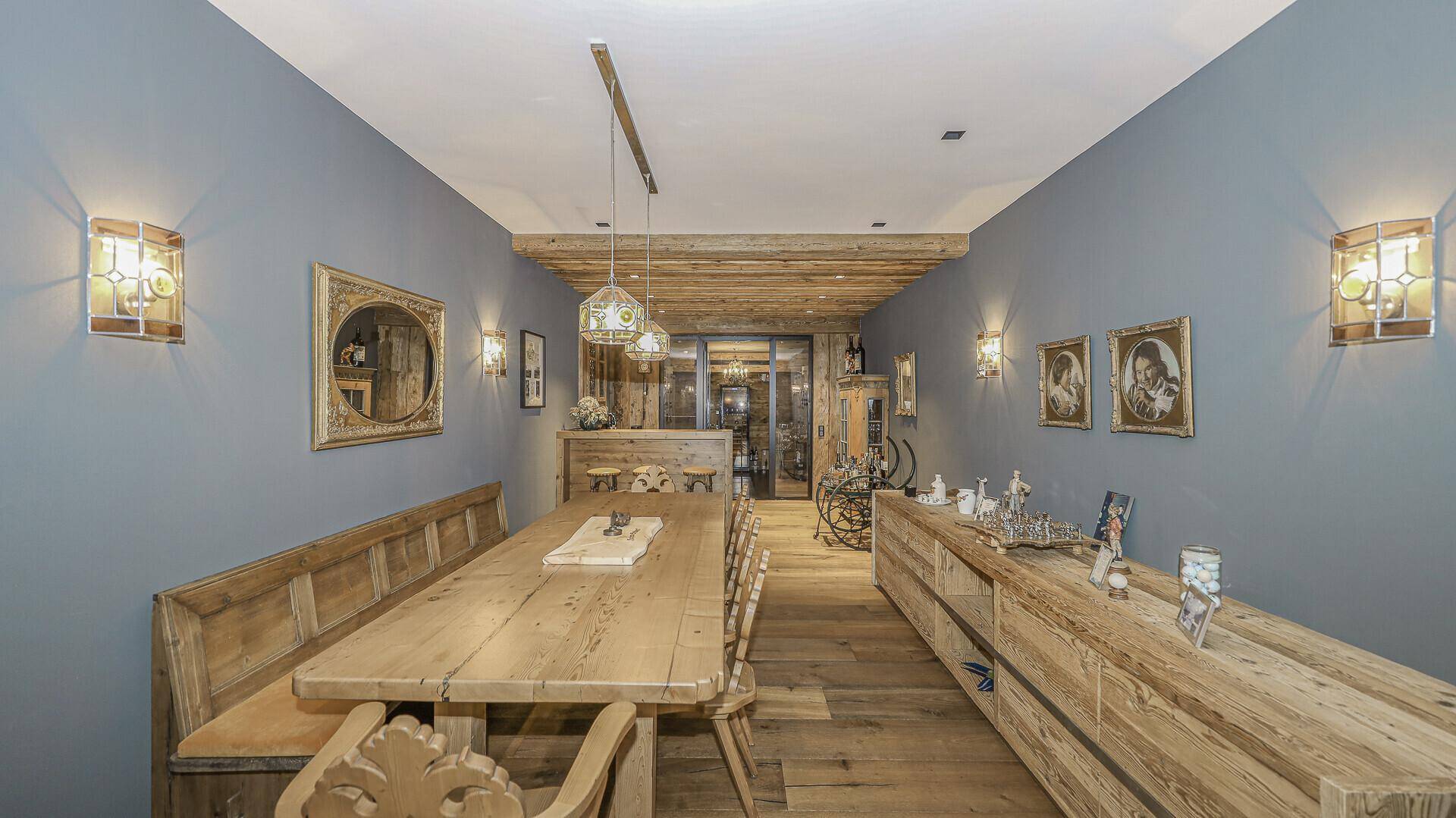 Gemütlicher Essbereich im alpinen Stil mit Holztisch, Bänken und rustikalen Wandleuchten.