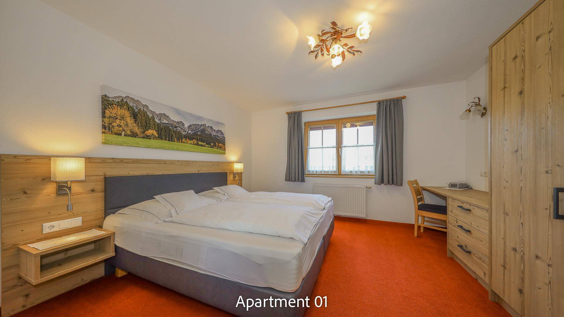 Komfortables Schlafzimmer mit Doppelbett, Holzmöbeln und Teppichboden.