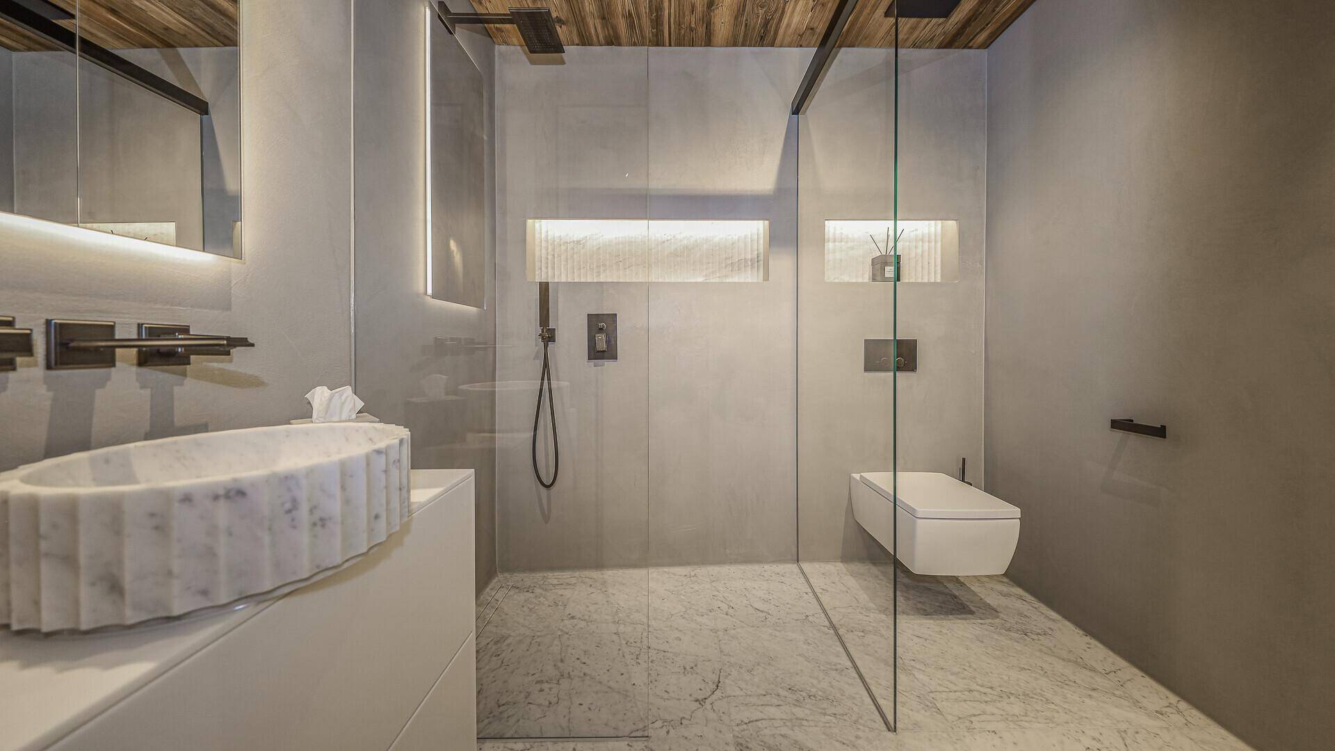 Modernes Badezimmer mit begehbarer Dusche, Marmorwaschbecken und Wand-WC.