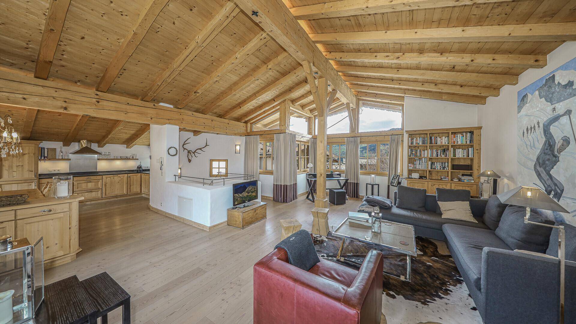 Offener Wohnbereich mit Holzbalkendecke, Kamin und integrierter Küche im traditionellen Stil.