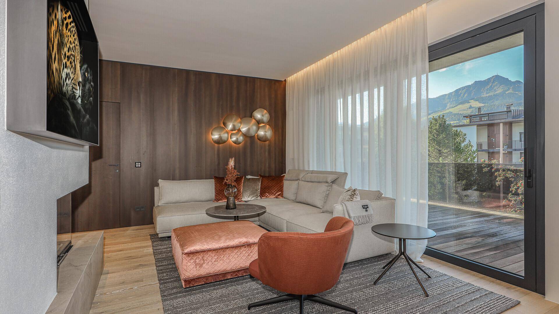 Helles Wohnzimmer mit Bergblick, raumhohen Fenstern und einer modernen Sitzecke.