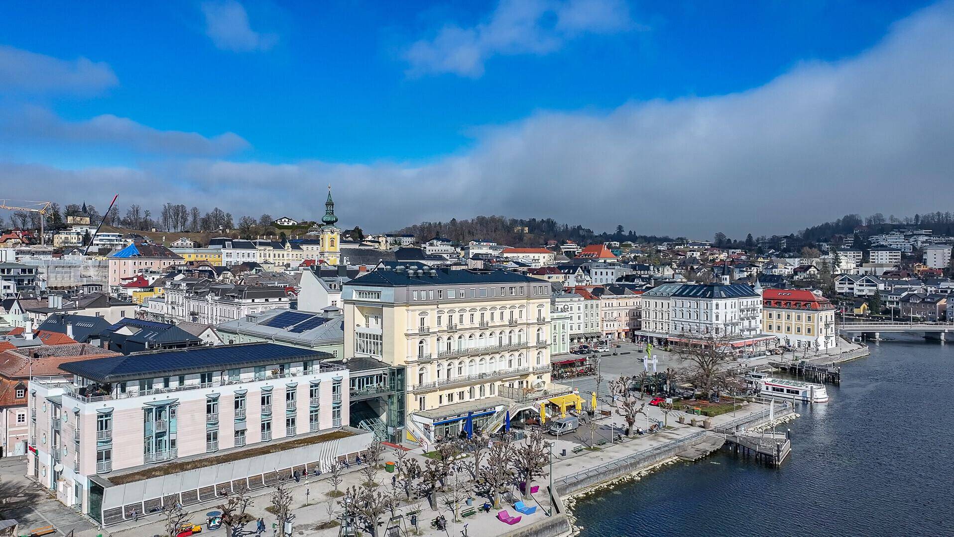 Historisches Gebäude an der Seepromenade mit Blick auf die Stadt und die umliegende Landschaft.