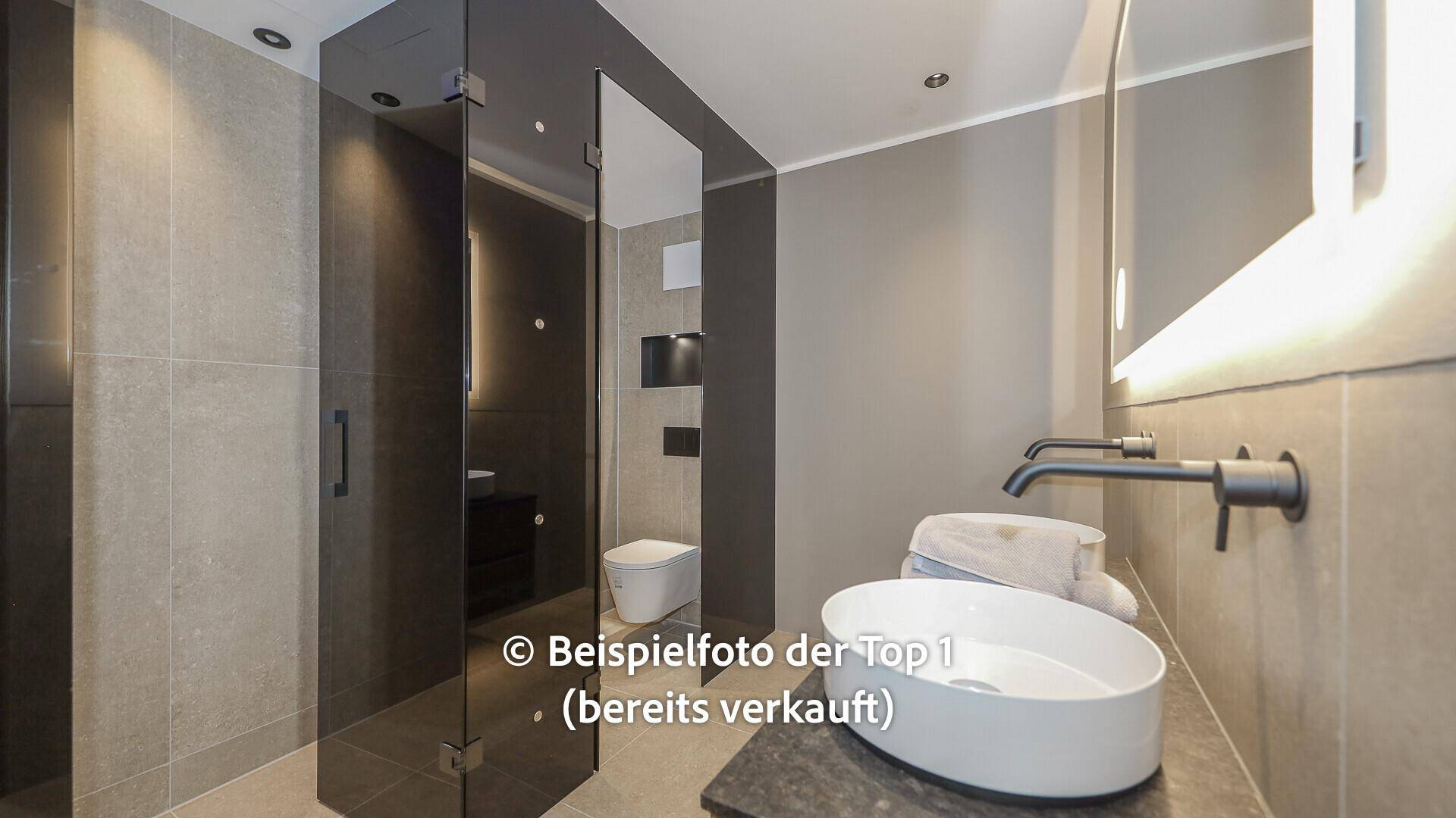 Stilvolles Badezimmer mit modernem Waschbecken und großer Duschkabine aus Glas.