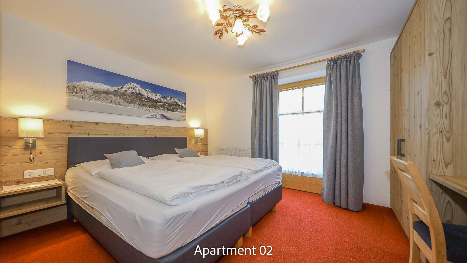 Helles Schlafzimmer mit Doppelbett, Holzvertäfelung und Bergblick.