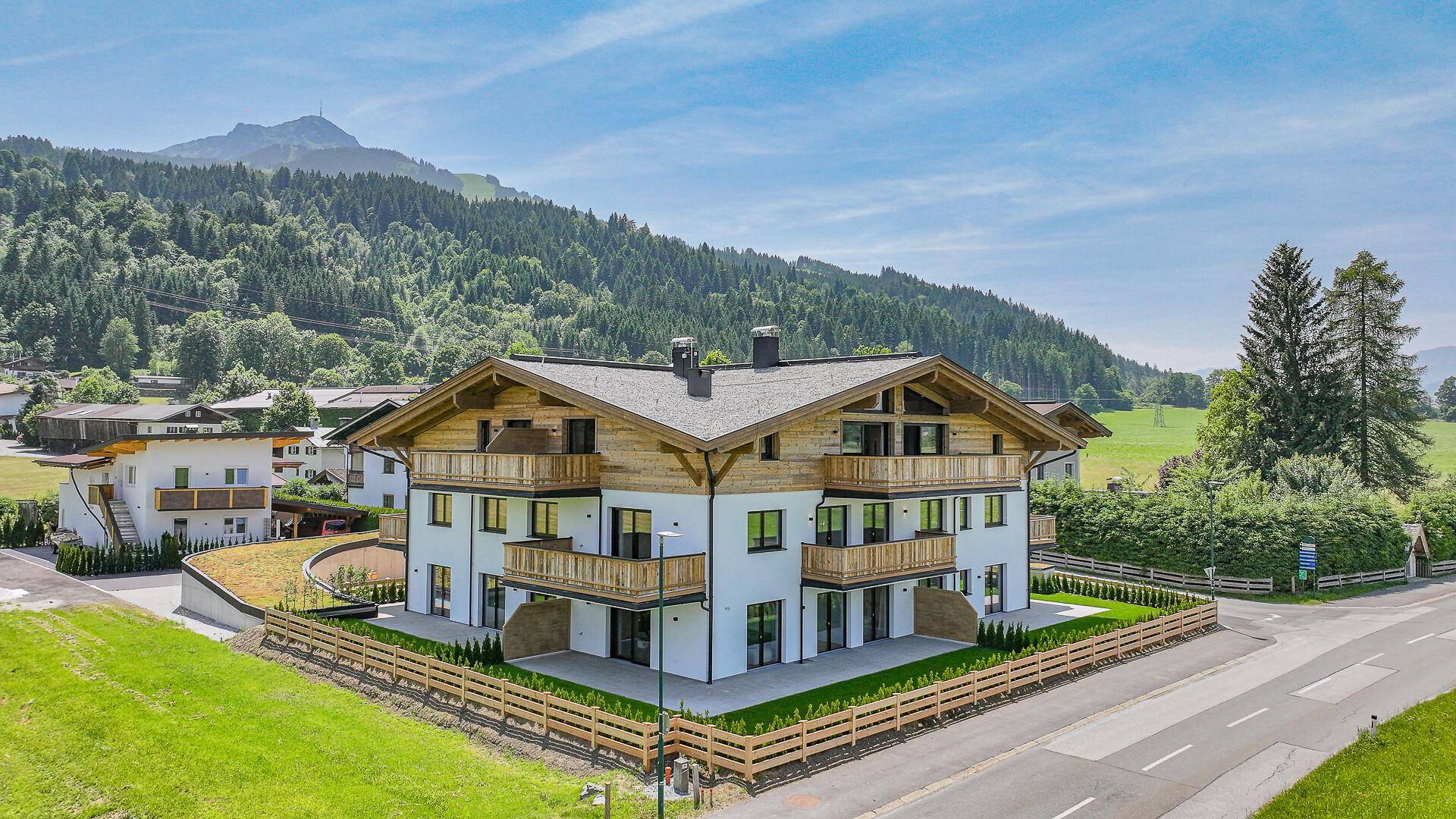 Attraktives Neubau-Wohnhaus mit traditionellen Holzbalkonen in ländlicher Umgebung.