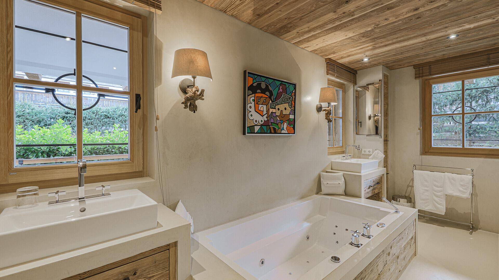 Luxuriöses Badezimmer mit Whirlpool-Badewanne, Doppelwaschbecken und Holzdecke.