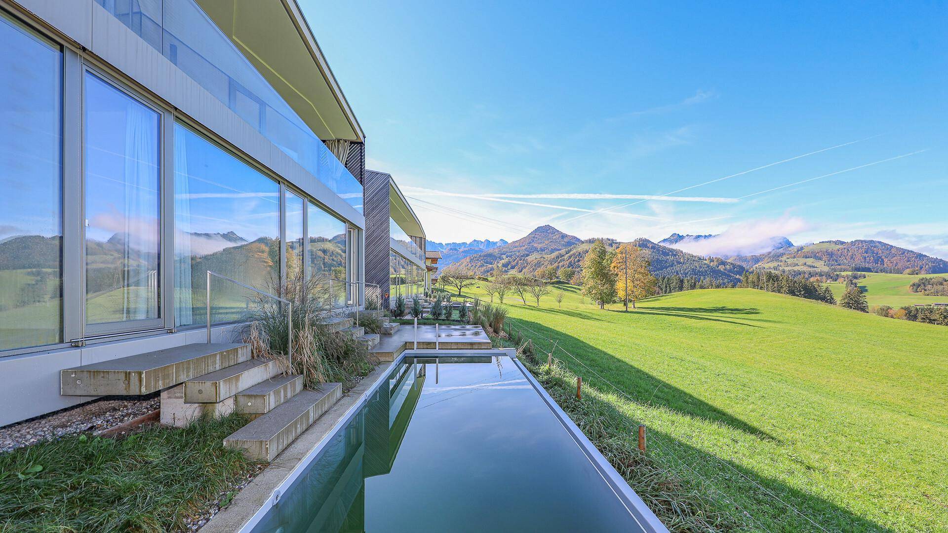 Außenbereich mit langem Pool und Panoramablick auf die umliegende Berglandschaft.