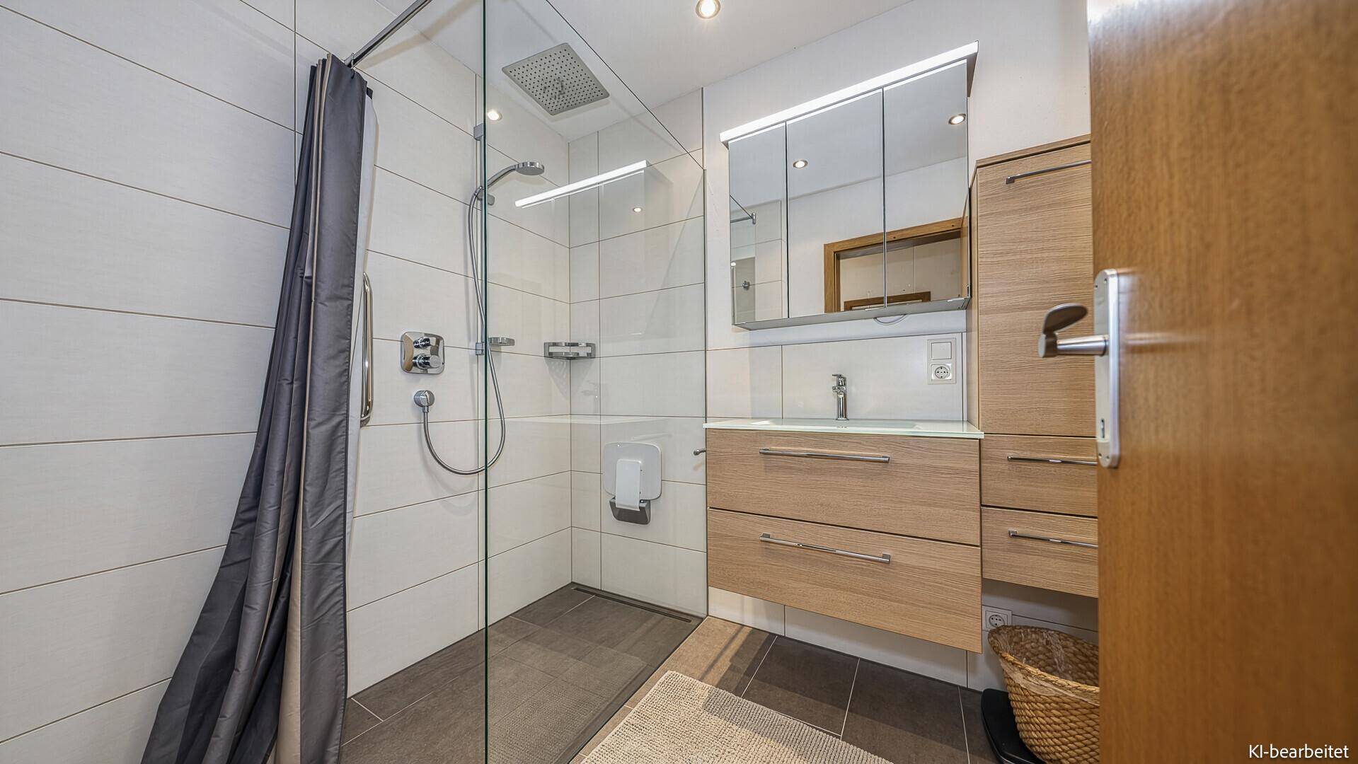 Helles Badezimmer mit begehbarer Dusche, Einzelwaschbecken und Spiegelschrank.