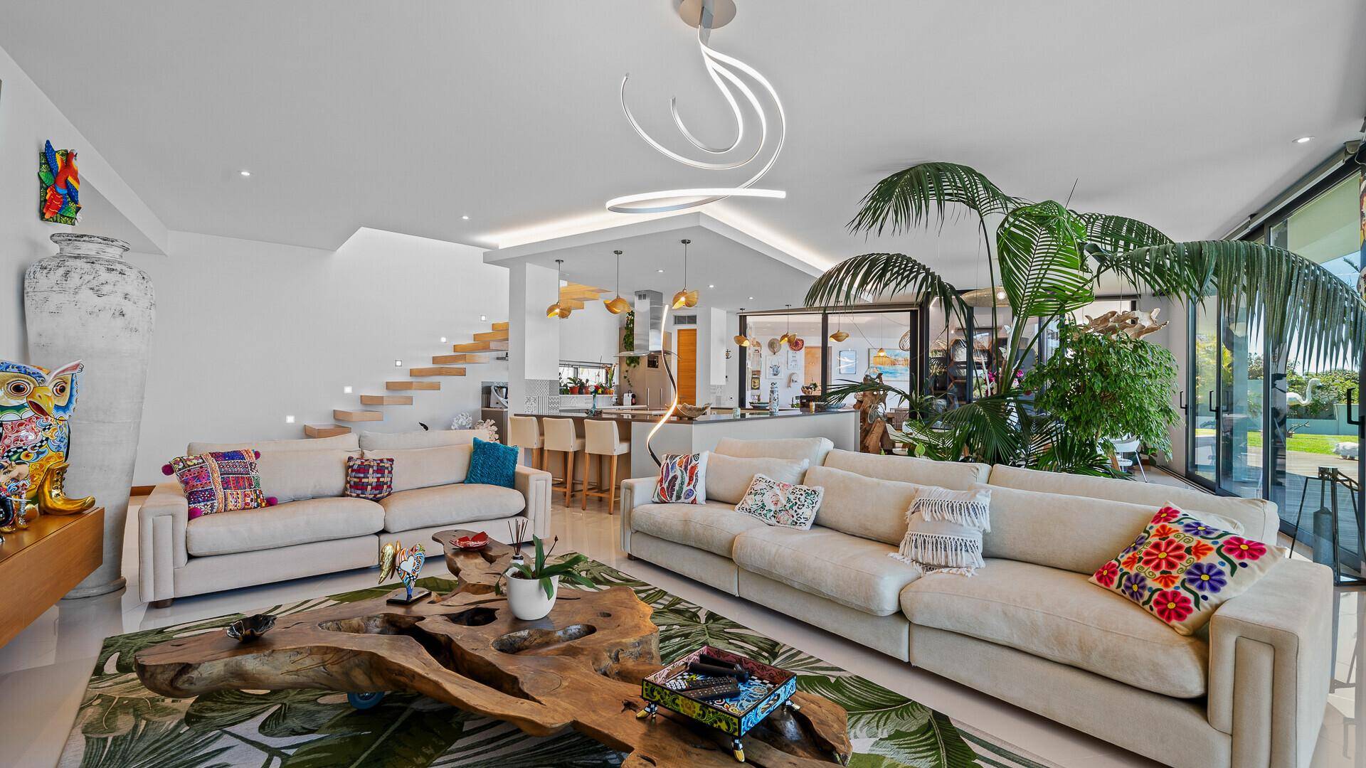 Großzügiges Wohnzimmer mit zwei Sofas und einem einzigartigen Holztisch, offen zum Essbereich und zur Küche.