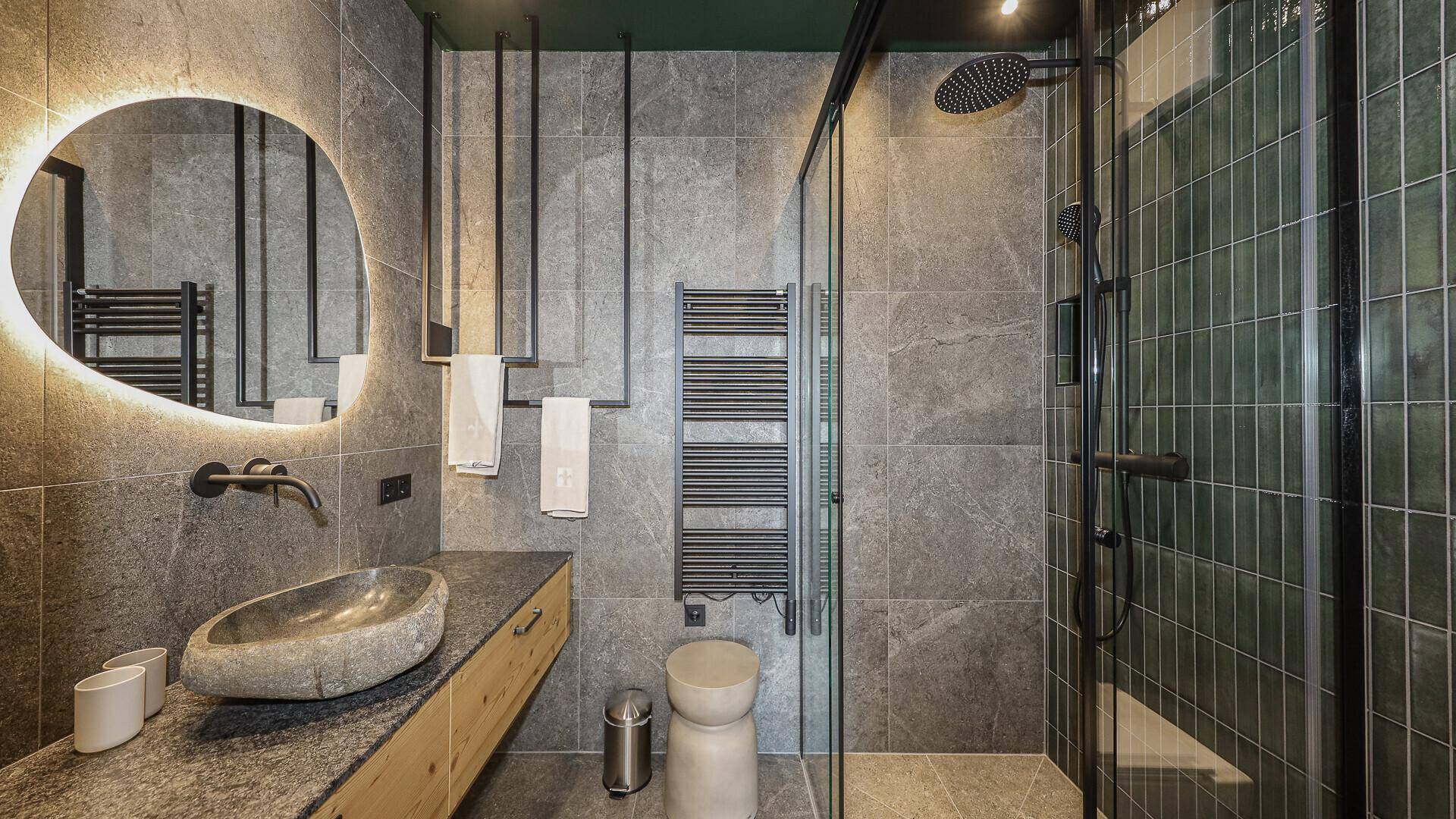 Modernes Badezimmer mit grauen Fliesen, Natursteinwaschbecken und großer begehbarer Dusche.