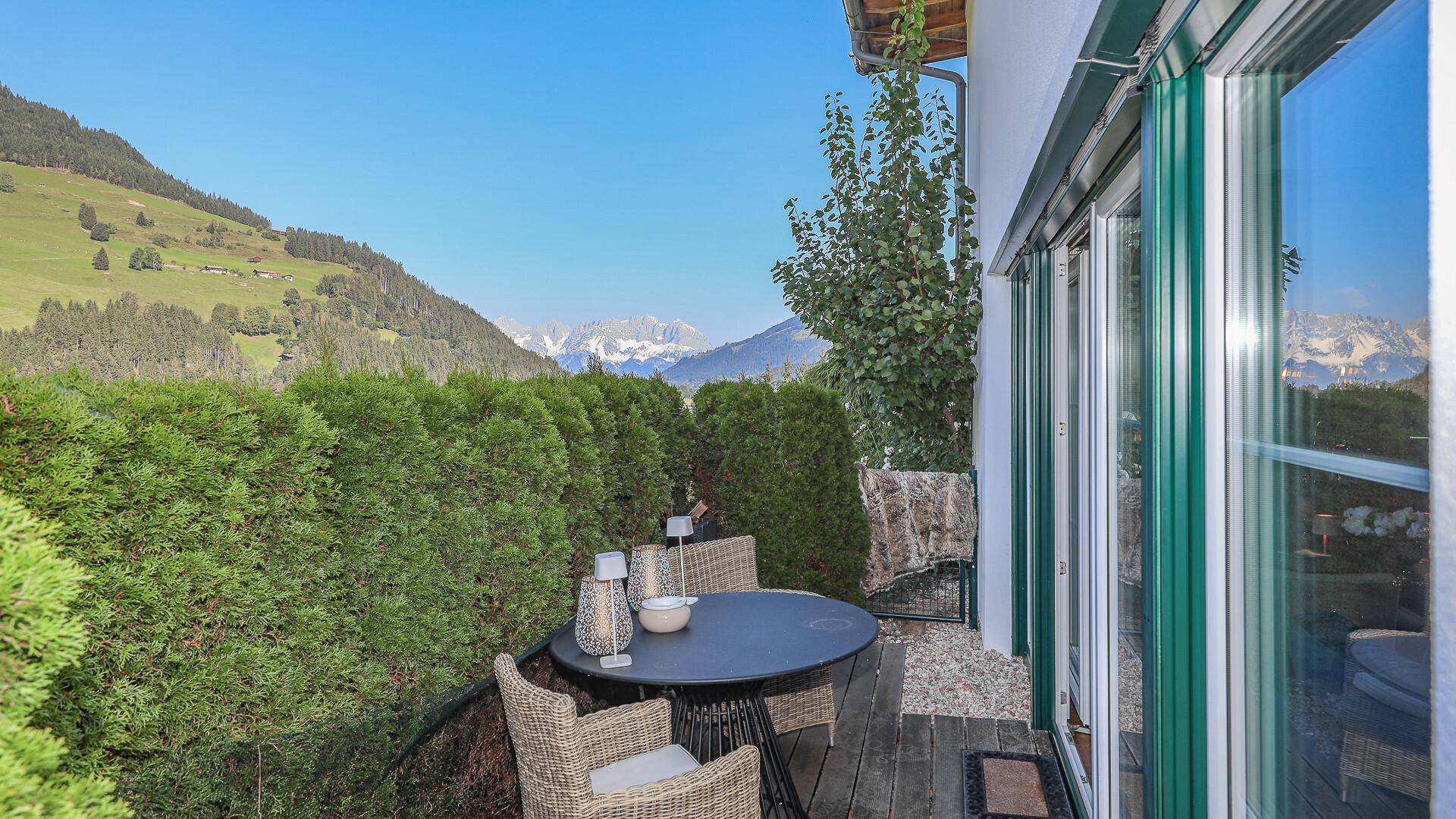 Kleiner Balkon mit Sitzgelegenheiten und weitem Blick auf die Berge und grüne Natur.