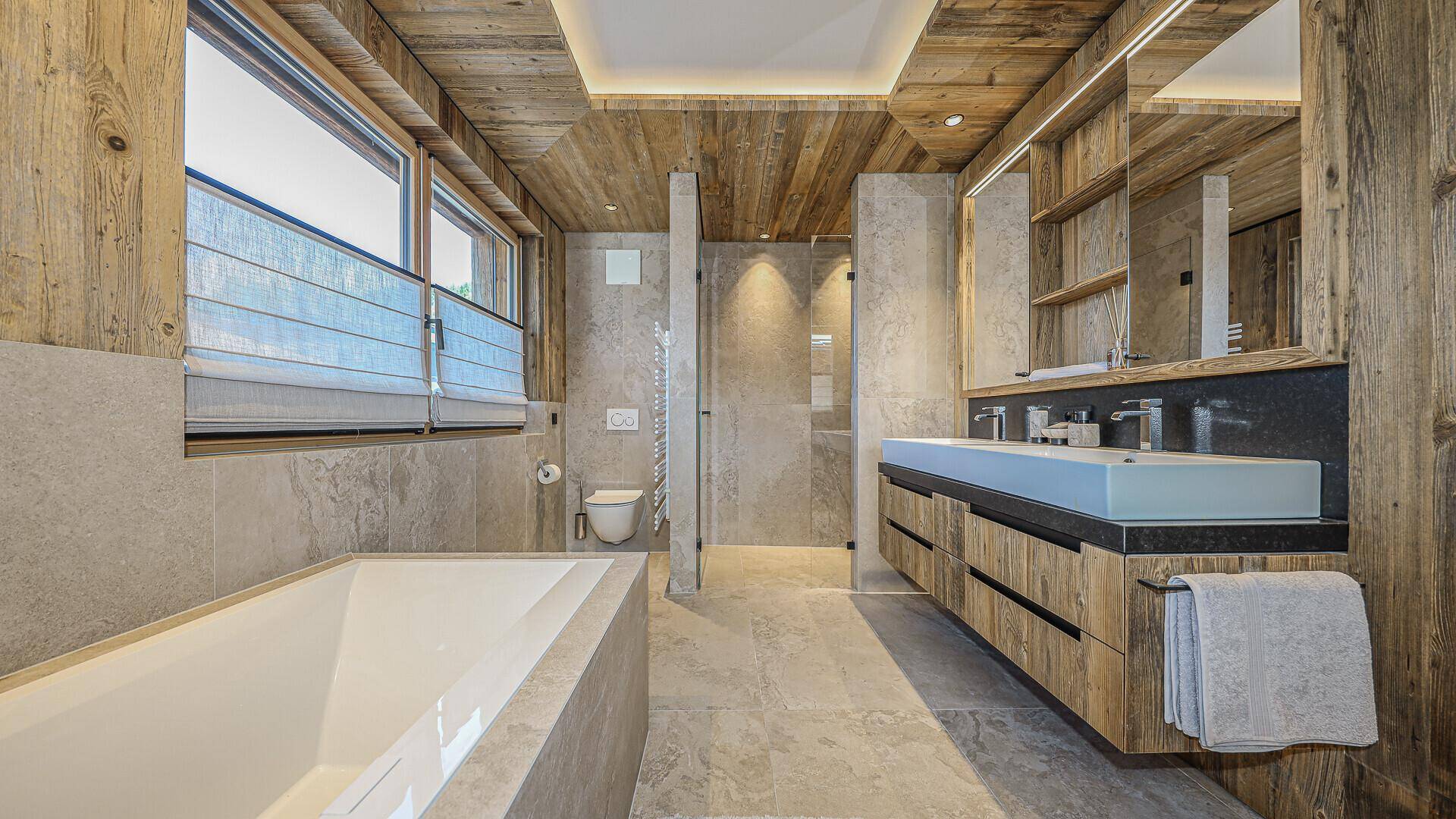 Modernes Badezimmer mit Badewanne, Doppelwaschbecken und begehbarer Dusche.
