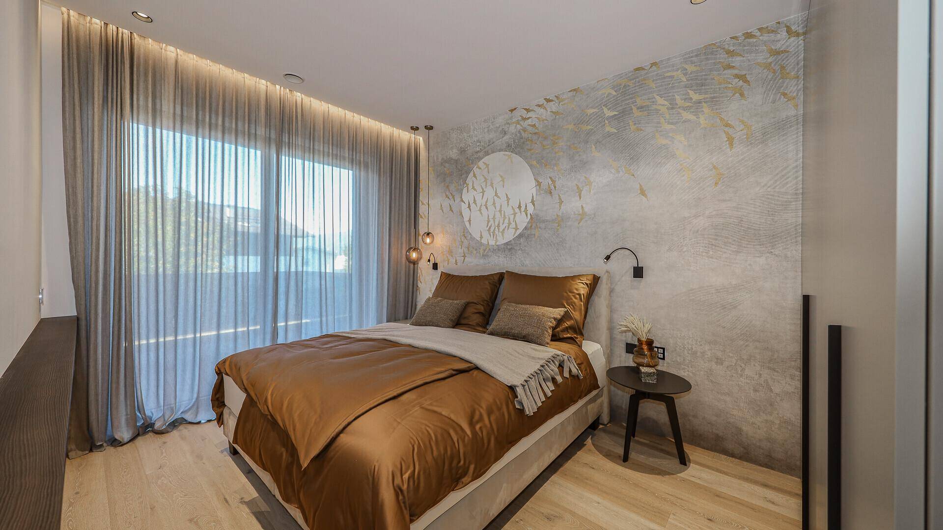 Helles Schlafzimmer mit dekorativer Wandgestaltung, großem Bett und Zugang zum Balkon.