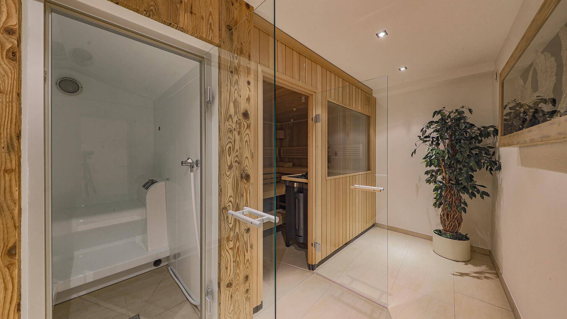 Wellnessbereich mit Dampfdusche und traditioneller Holzsauna für entspannende Momente.