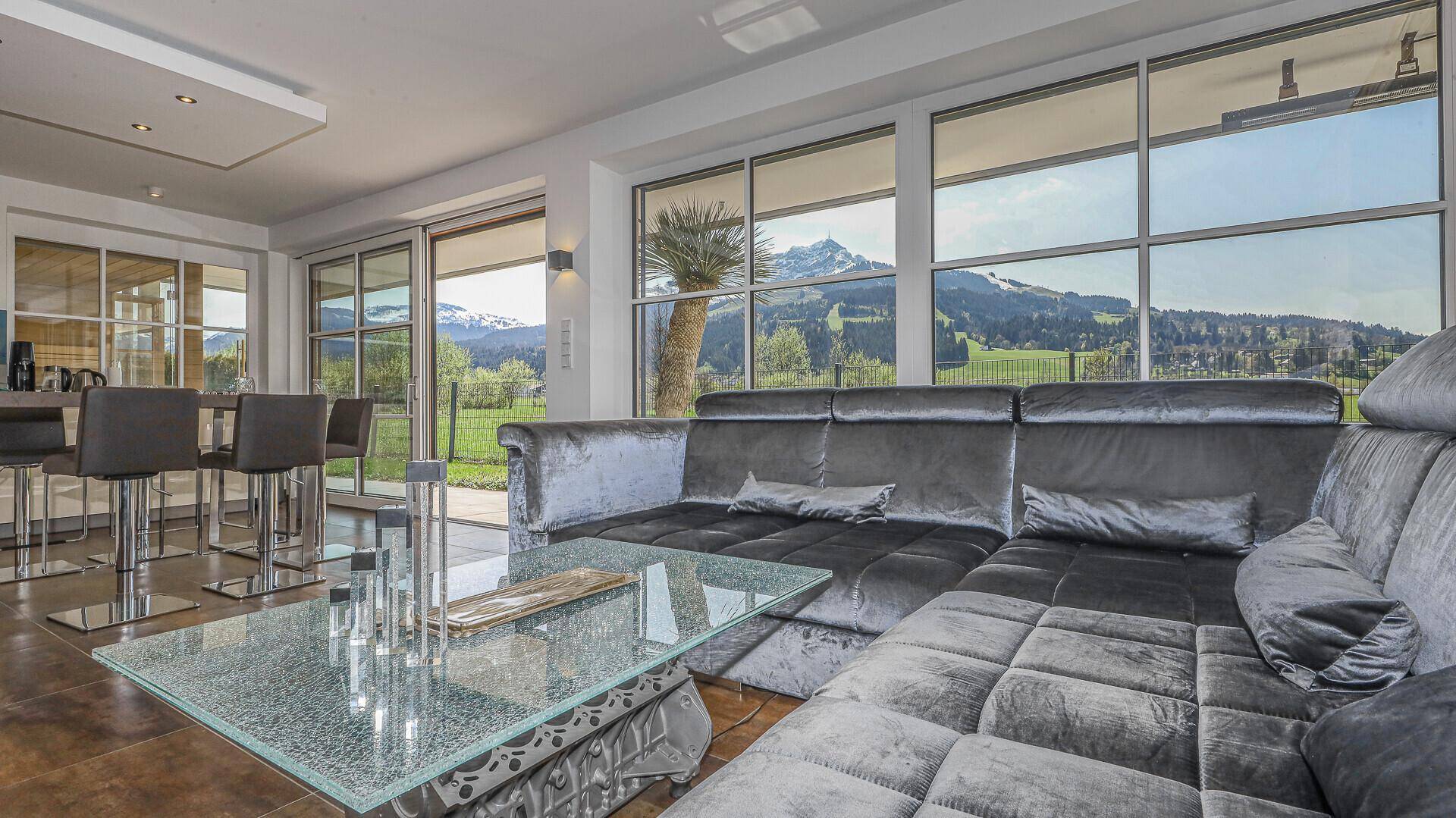 Gemütliche Sitzecke im Wohnzimmer mit bodentiefen Fenstern und atemberaubendem Bergblick.