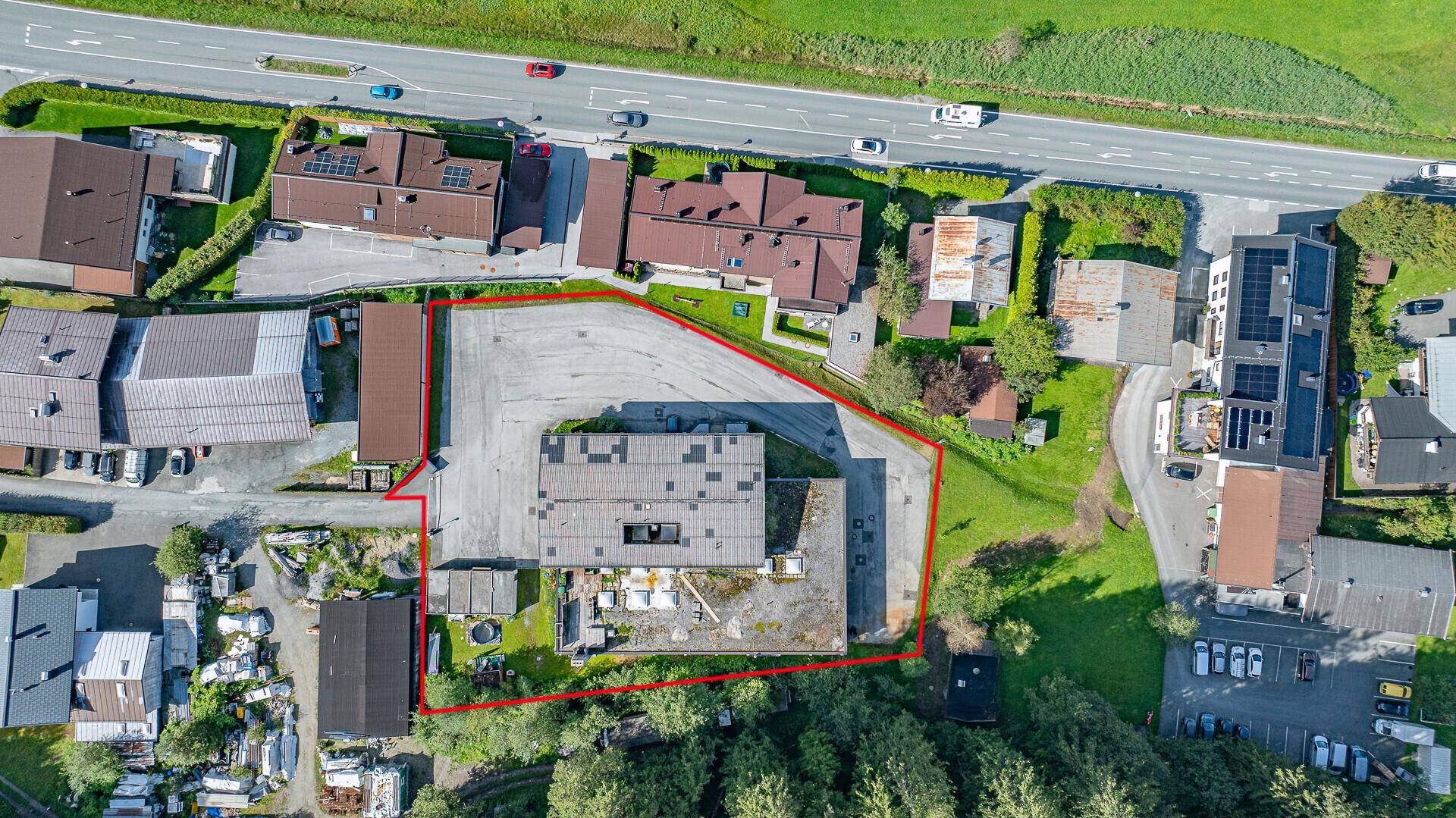 Draufsicht des umrandeten Grundstücks mit angrenzender Straße und Parkflächen.