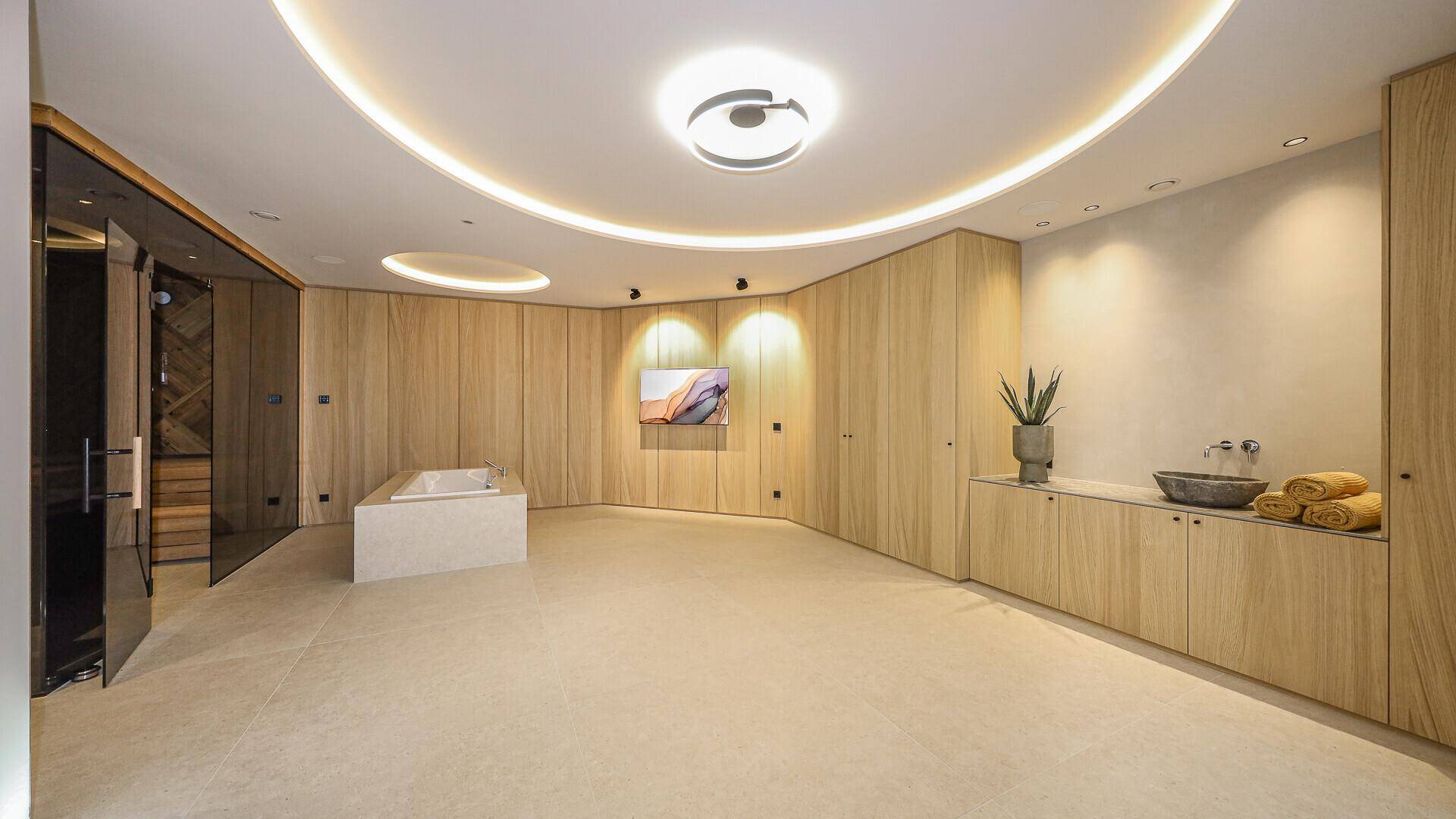 Exklusiver Wellnessbereich mit Whirlpool, Sauna und stilvoller Holzverkleidung für pure Entspannung.