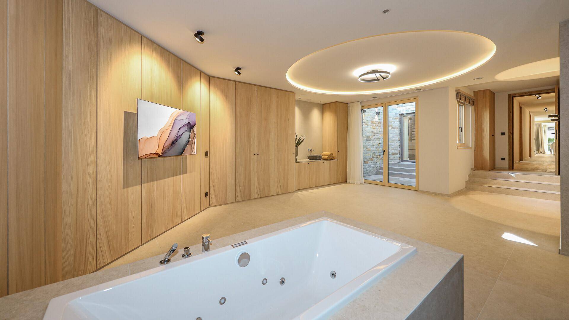 Luxuriöser Wellnessbereich mit Whirlpool, Holzverkleidung und indirekter Beleuchtung.