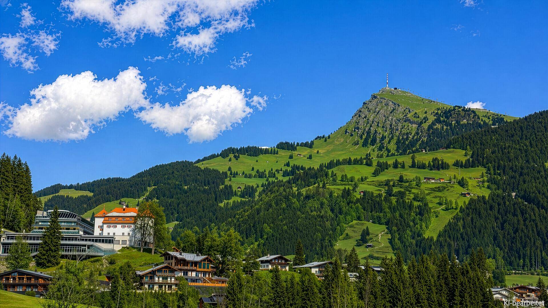 Malerische Berglandschaft mit grünen Hügeln, Wäldern und traditionellen Gebäuden.
