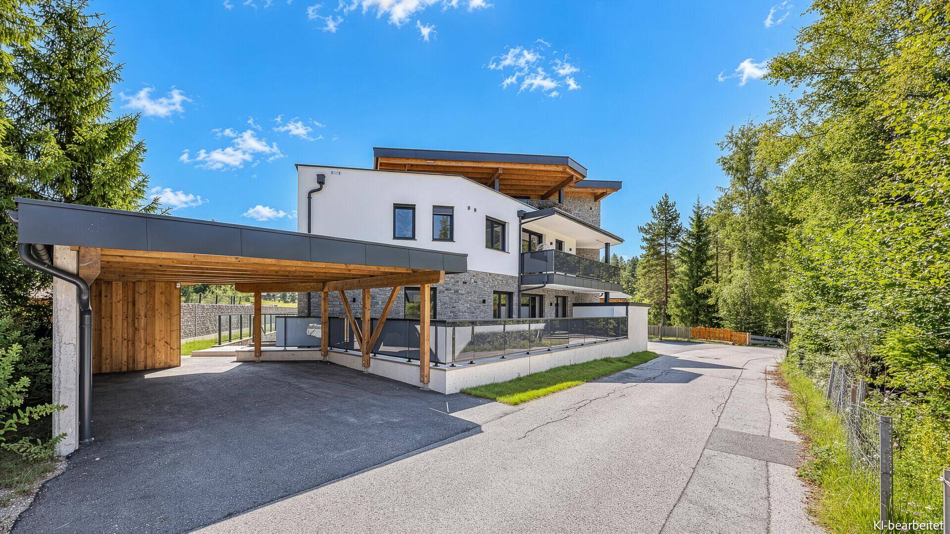Moderne Architektur des Gebäudes mit Carport und umgebender Natur.