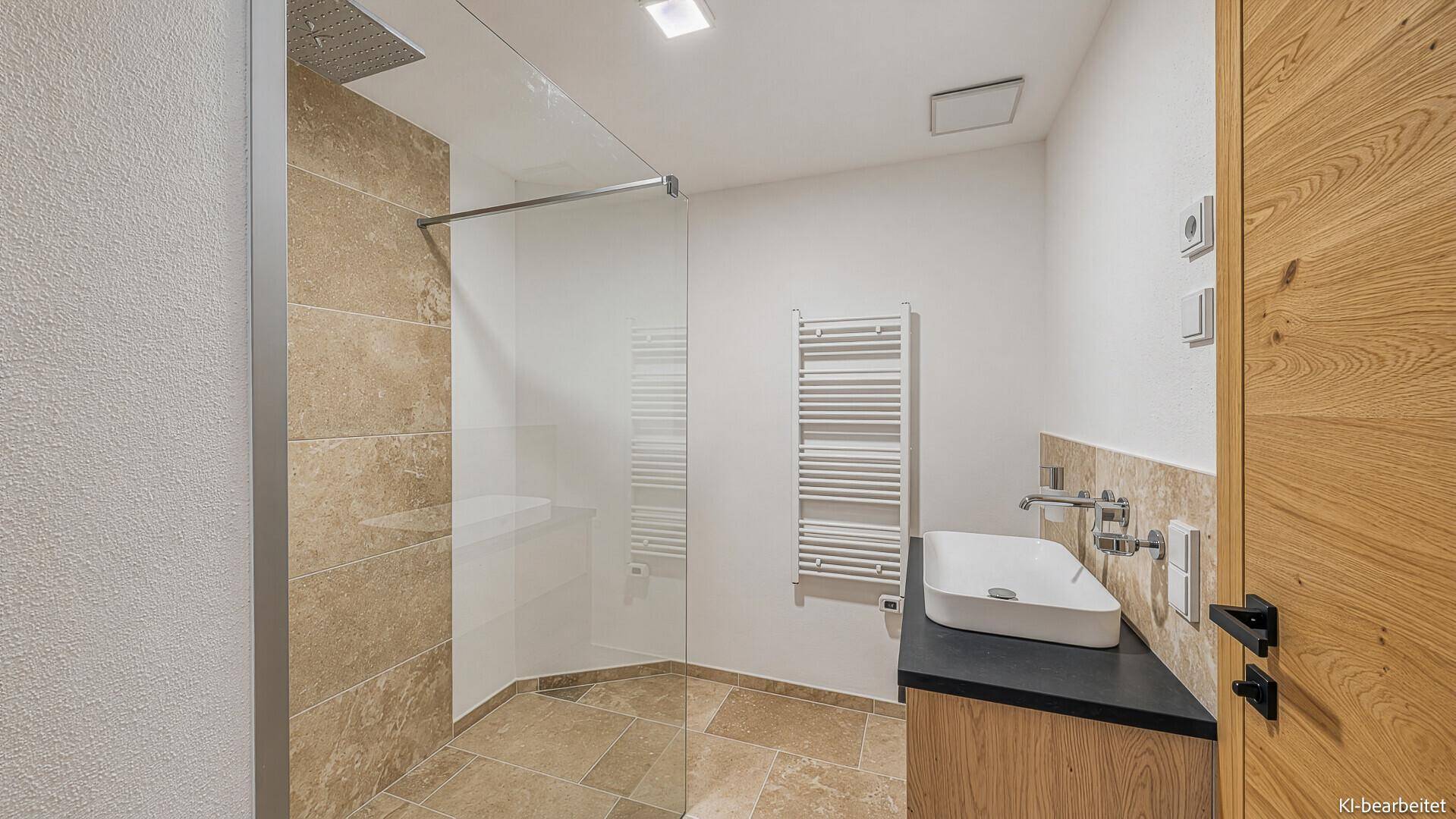 Modernes Badezimmer mit ebenerdiger Dusche, Waschtisch und beigen Fliesen.