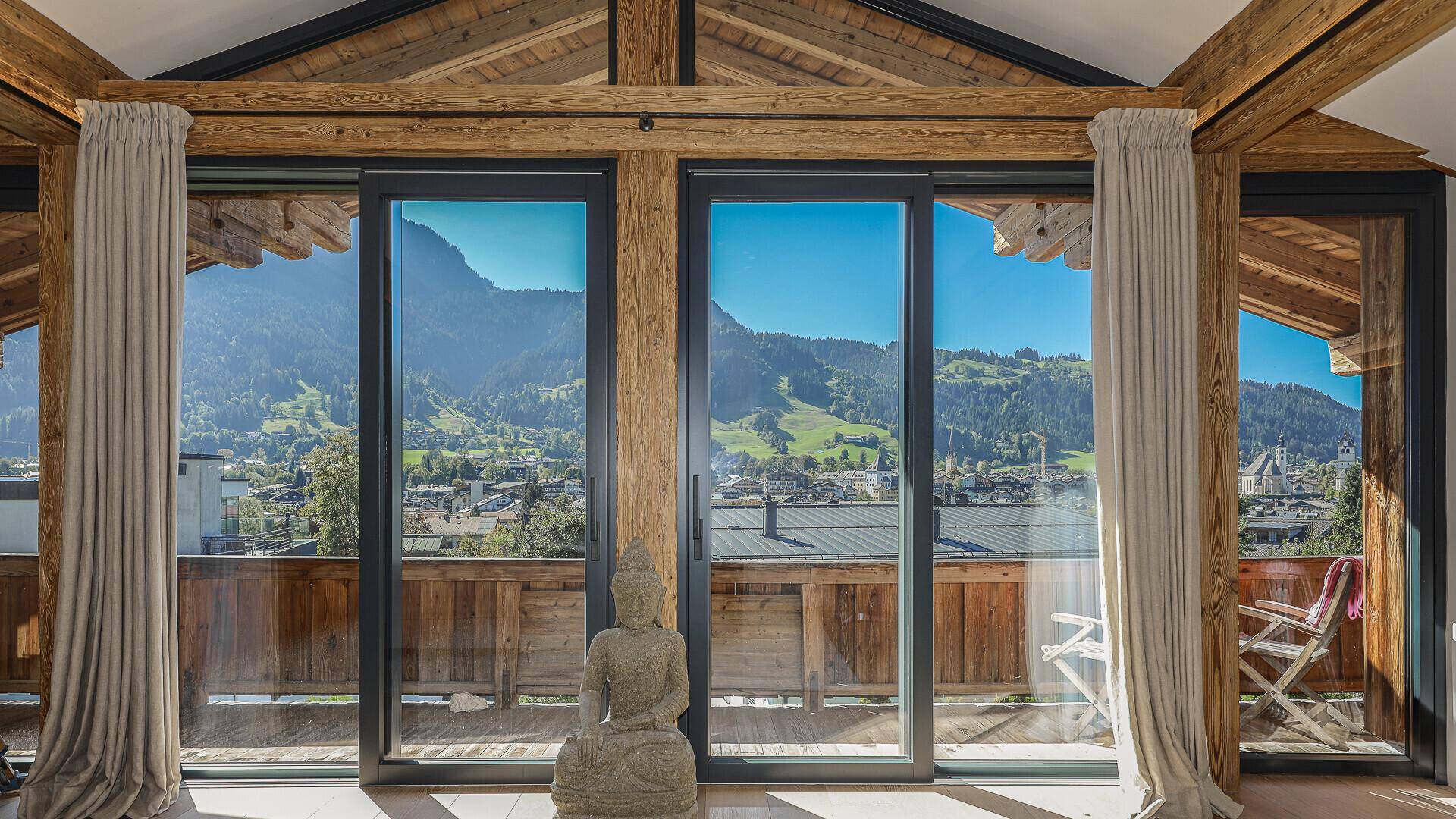 Weitläufige Fensterfront im Schlafzimmer bietet einen atemberaubenden Blick auf die Alpenlandschaft.