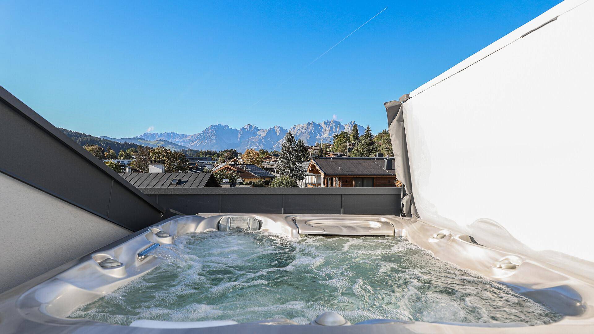 Luxuriöser Whirlpool auf dem Balkon mit spektakulärem Blick auf die umliegende Bergwelt.