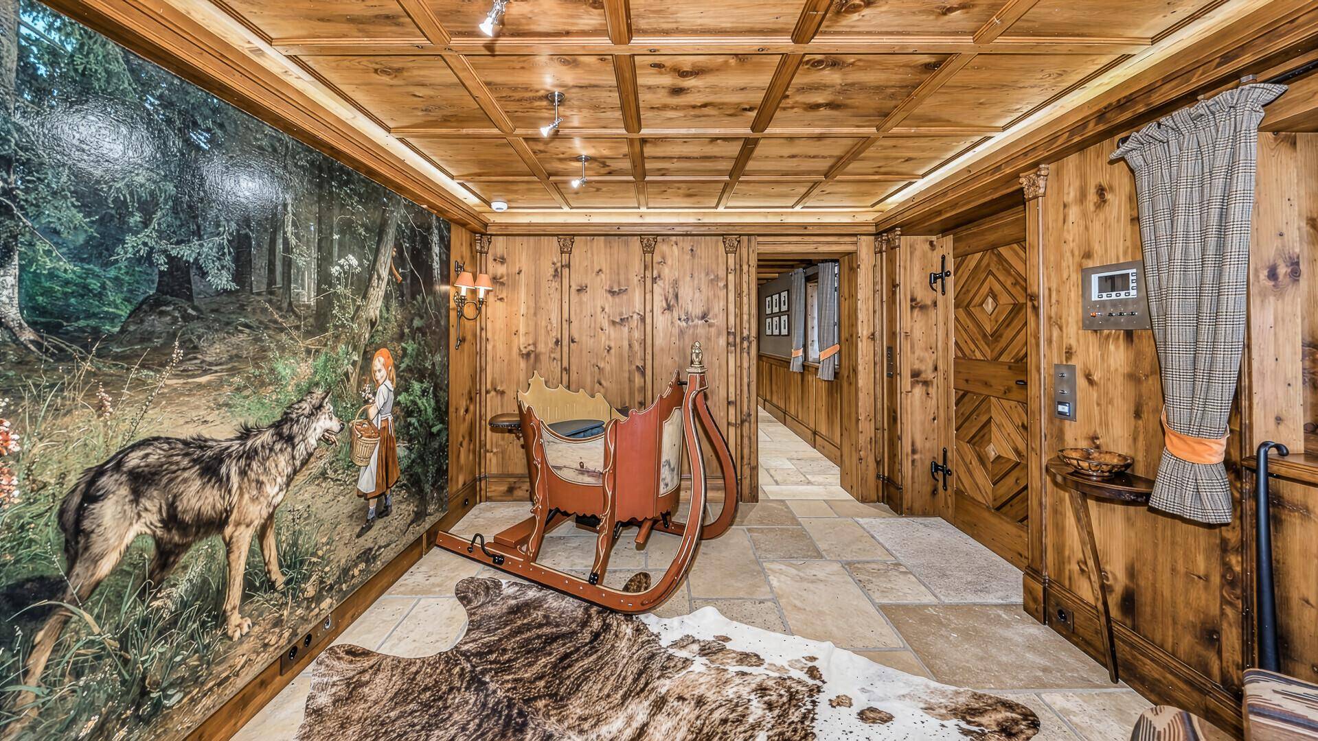 Rustikaler Flur mit Holzvertäfelung, Steinboden und einem großen Wandgemälde mit Waldmotiv.