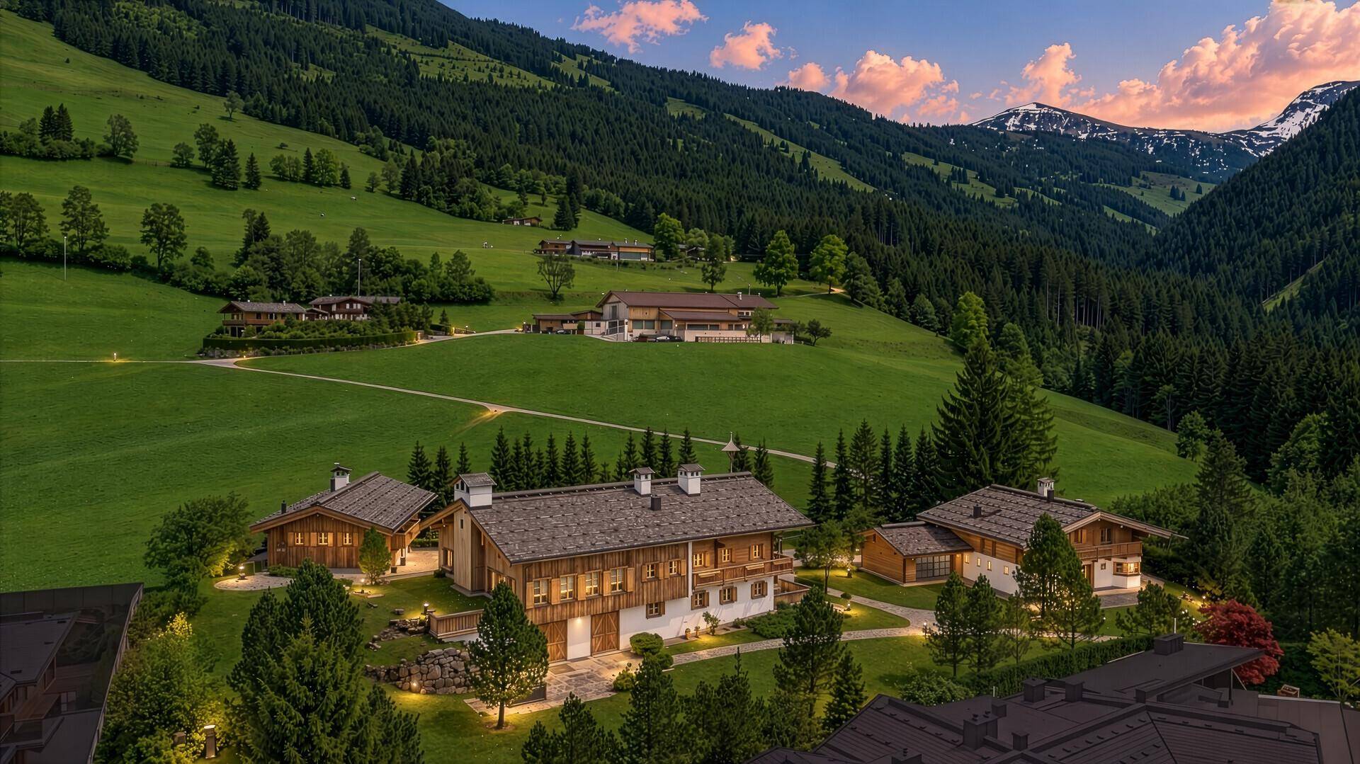 Abendlicher Panoramablick auf beleuchtete Chalets in einer malerischen Berglandschaft.