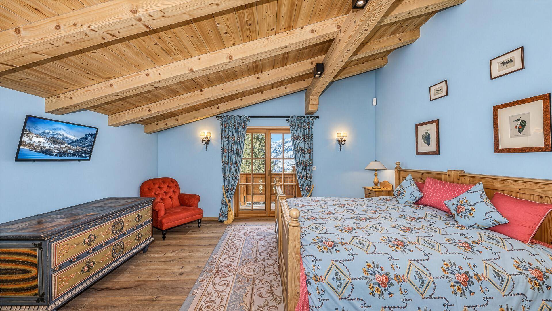 Gemütliches Schlafzimmer mit Holzbalkendecke, Balkonzugang und traditioneller Einrichtung.
