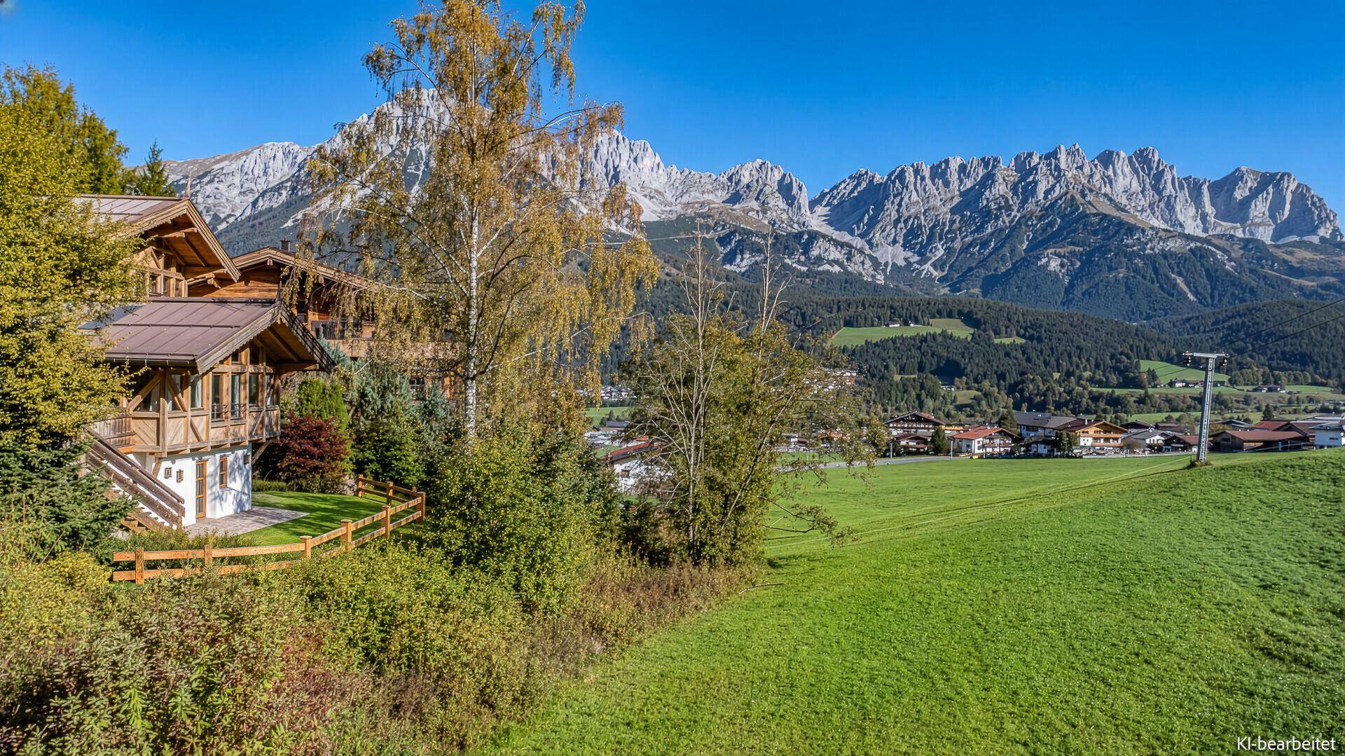 Malerisches Chalet in den Bergen mit weitem Blick über grüne Wiesen und Gipfel.