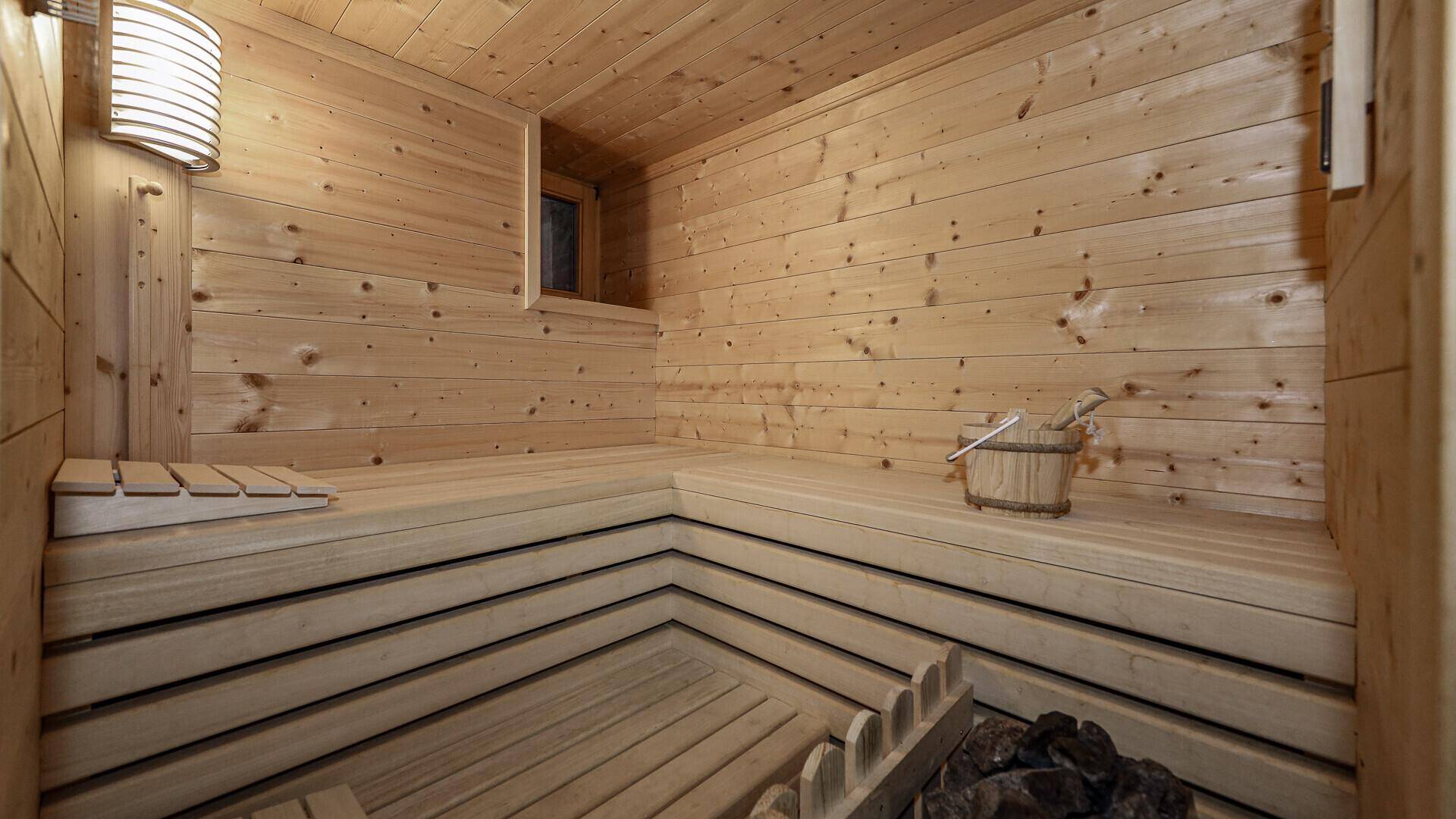 Gemütliche Holzsauna mit Bänken und Saunaofen für entspannende Momente.