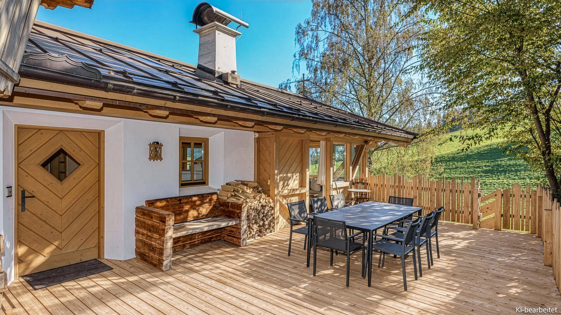 Große Holzterrasse mit Esstisch und Sitzgelegenheiten, ideal für Mahlzeiten im Freien.