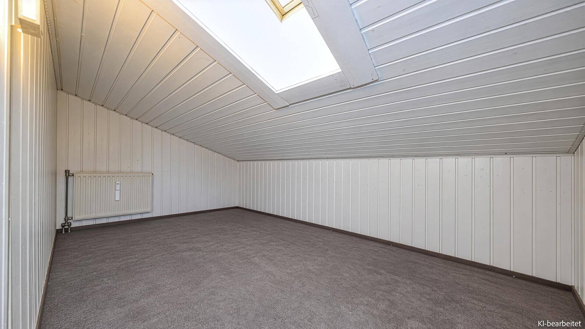 Helles Dachzimmer mit Holzverkleidung, Teppichboden und einem Dachfenster für natürliches Licht.