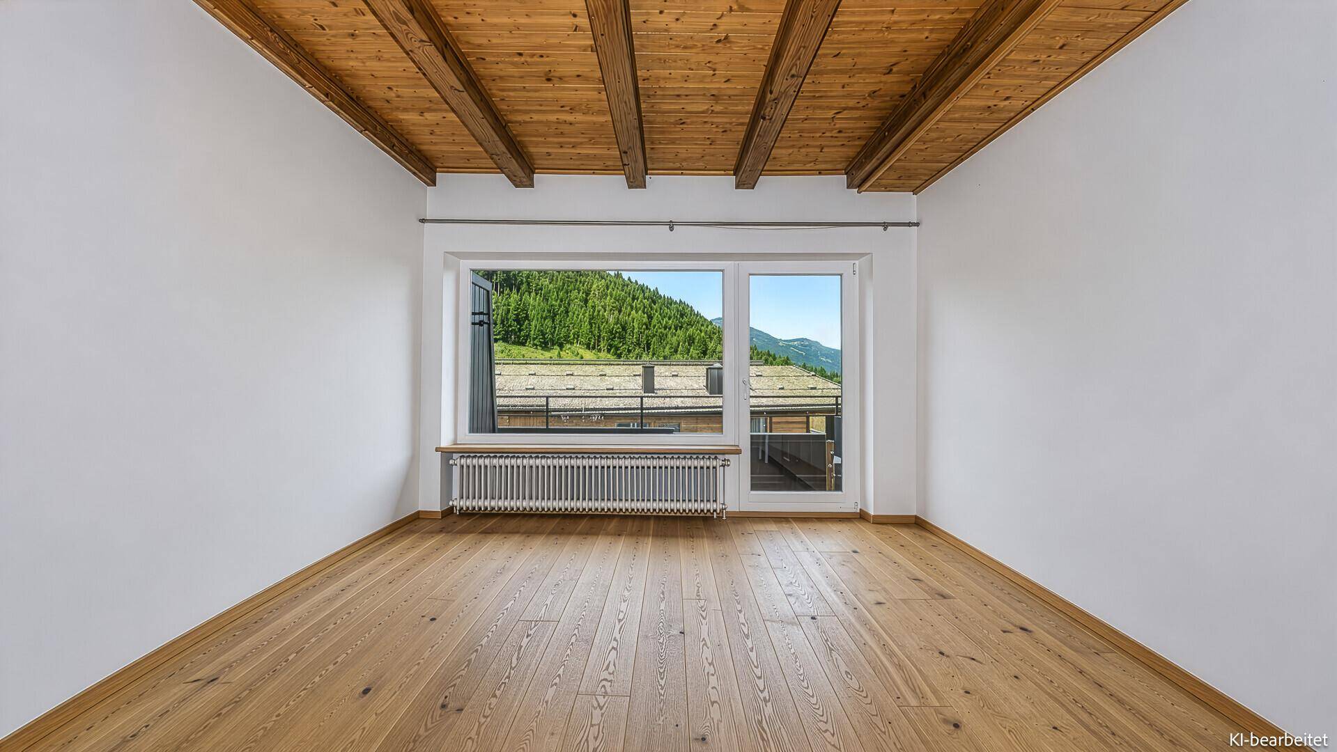 Helles, leeres Zimmer mit Holzbalkendecke und Parkettboden, bietet einen weiten Blick auf die Berge.