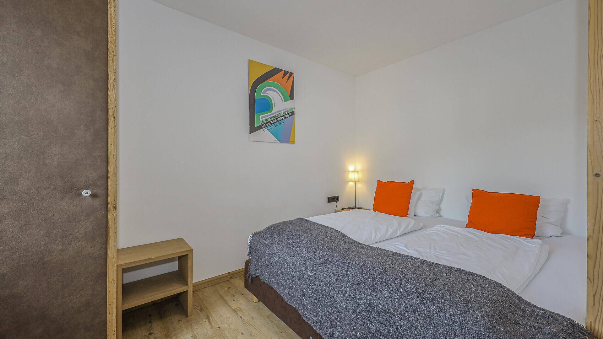 Helles Schlafzimmer mit zwei Einzelbetten, modernen Kunstwerken und schlichter Einrichtung.
